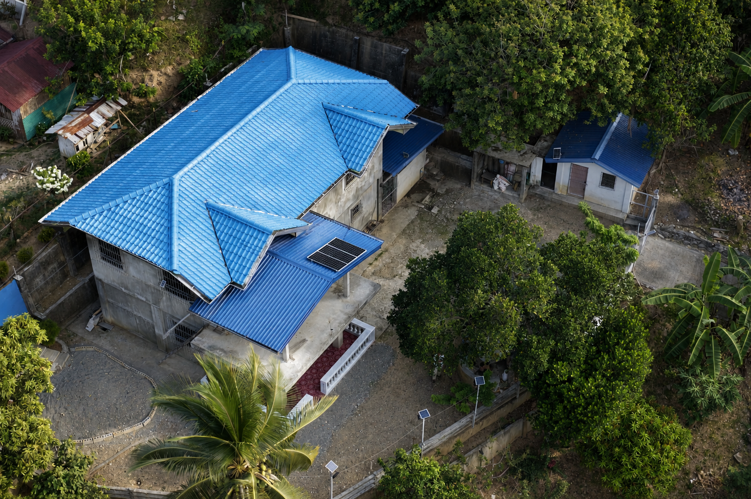 Close aerial view of the two-storey Dulangan house, solar panels and separate outbuilding